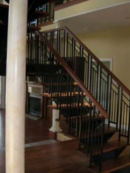 A wooden staircase with a metal railing in a house