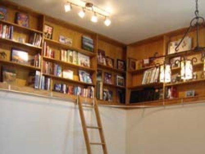 A library with a ladder going up to the second floor.
