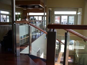 A staircase with a glass railing and wooden handrails