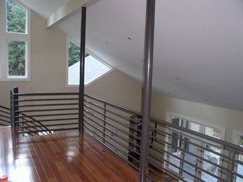 A balcony with a railing and stairs in a house.