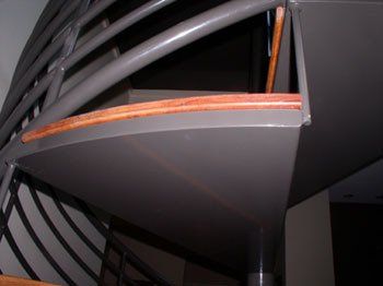 A spiral staircase with a metal railing and wooden steps