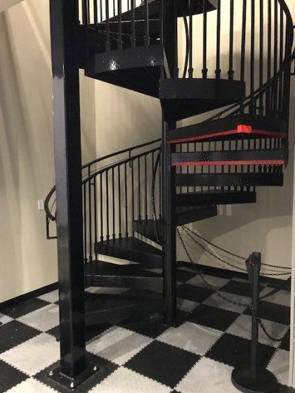 A black spiral staircase with a checkered floor