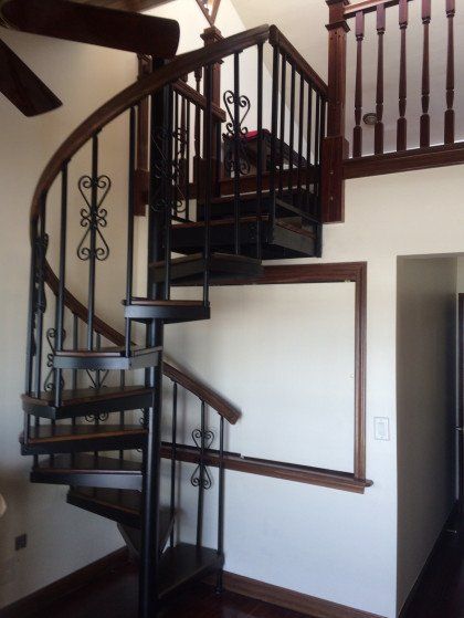 A spiral staircase in a room with a ceiling fan