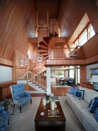 A living room with a spiral staircase leading to the second floor
