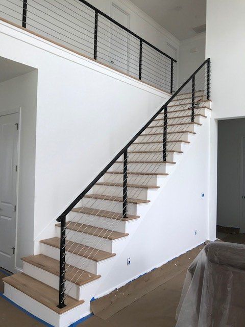 A staircase with a black railing in a white room
