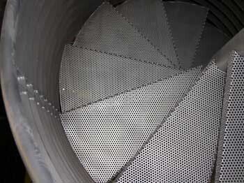 A close up of a spiral staircase made of perforated metal.