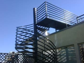 A spiral staircase with a railing on top of a building.