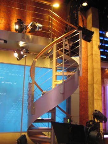 A spiral staircase in a room with a blue wall