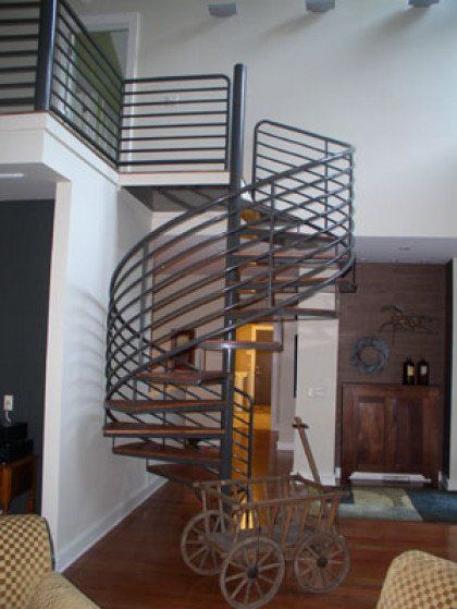 A living room with a spiral staircase leading up to the second floor