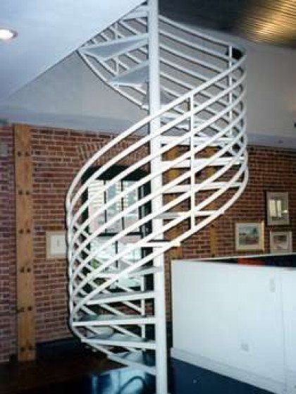 A spiral staircase in a room with a brick wall