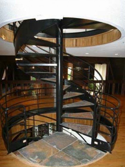 A spiral staircase with a metal railing in a room
