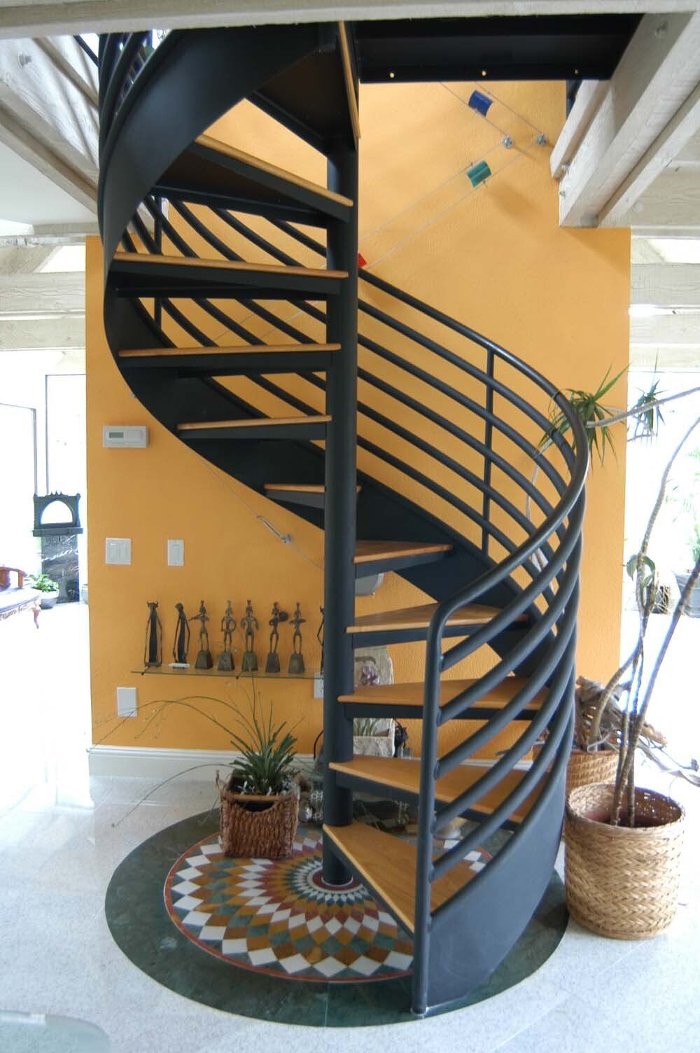 A spiral staircase with a yellow wall behind it