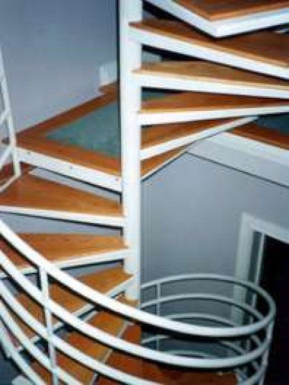A spiral staircase with wooden steps and a white railing.