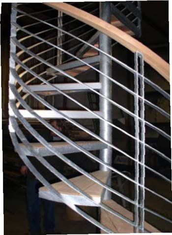 A spiral staircase with a metal railing and wooden steps