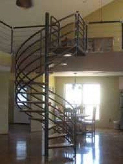 There is a spiral staircase in the middle of the room leading to the second floor.