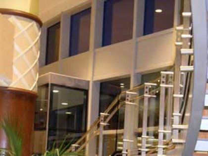 There is a staircase in the middle of a building with a glass railing.