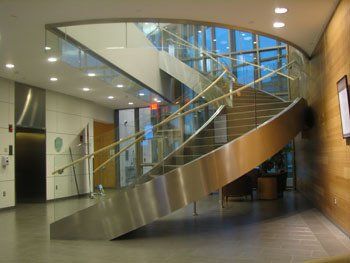 A spiral staircase in a building with a glass railing