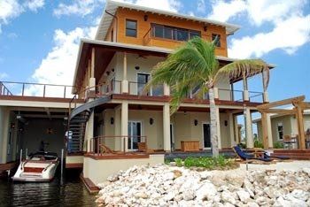 A large house with a boat docked in front of it