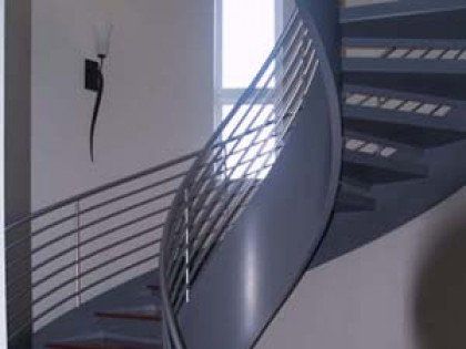 A spiral staircase with a stainless steel railing and a light on the wall.