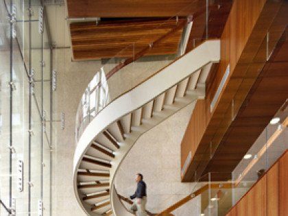 A man is walking up a spiral staircase in a building