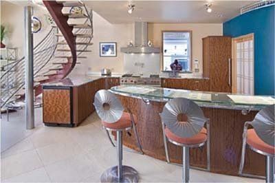 A kitchen with a staircase leading up to the second floor