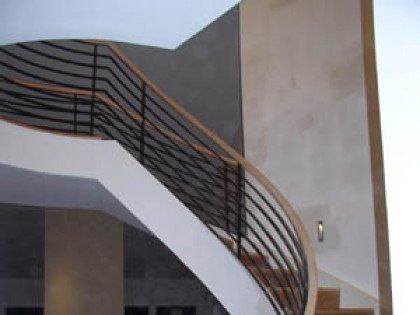 A staircase with a wooden handrail and a metal railing