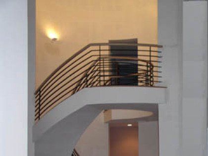 A staircase with a railing and a balcony in a building.