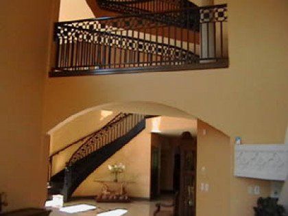 A staircase in a house with a wrought iron railing