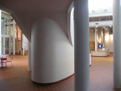 A hallway in a building with columns and tables