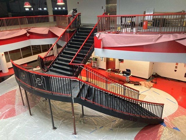A staircase with a red railing in a building