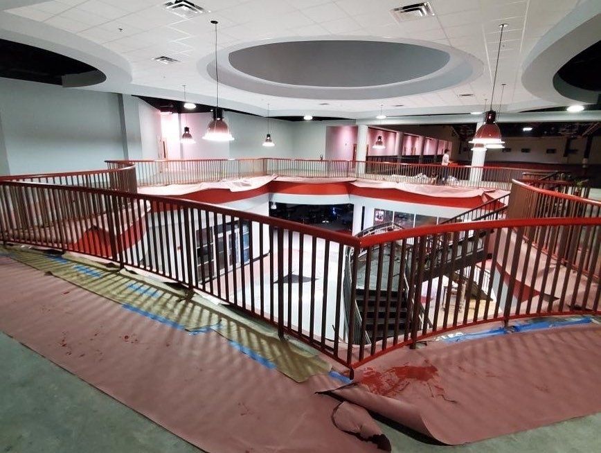 A building under construction with a red railing and stairs