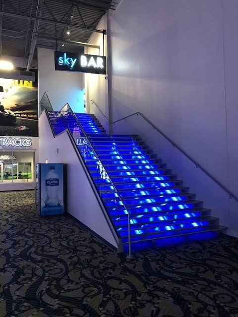 Stairs leading up to a sky bar with blue lights