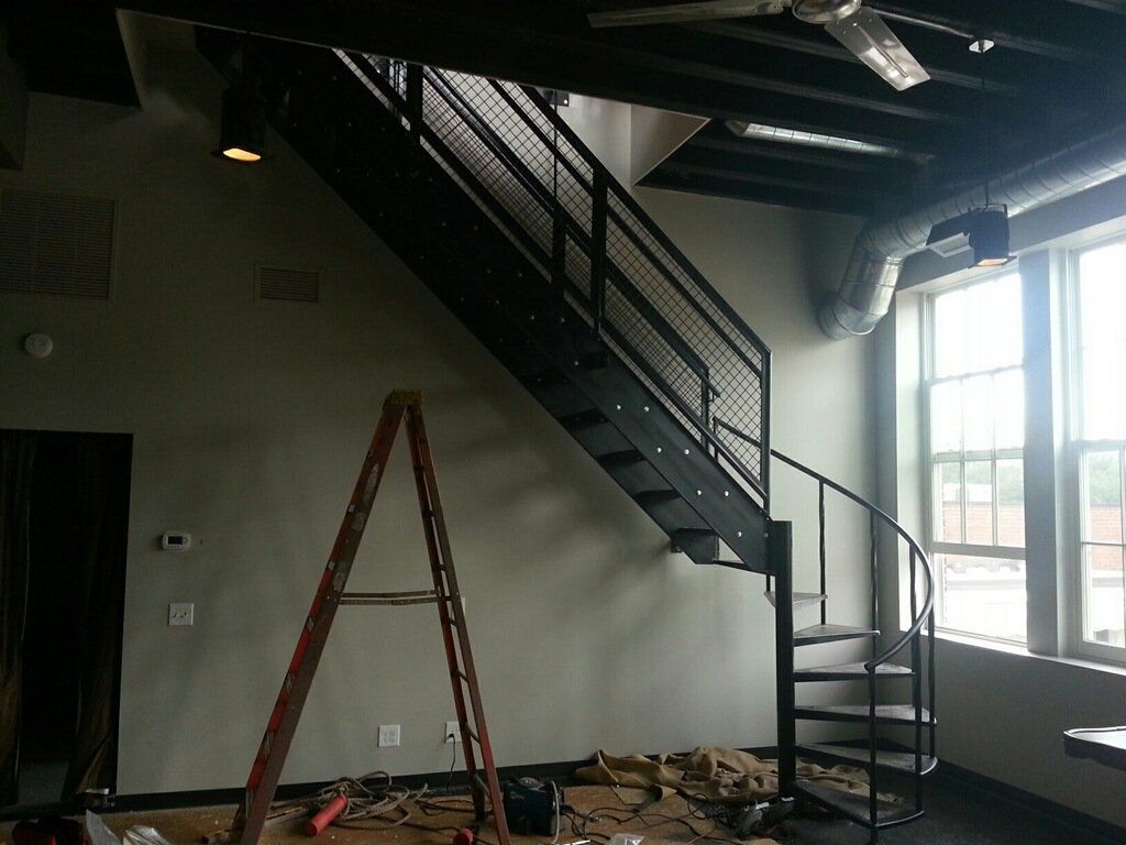 A room with a spiral staircase and a ladder