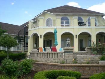 A large yellow house with a spiral staircase leading up to the second floor