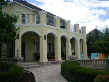 A large yellow house with arches and a balcony
