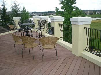 A deck with wicker chairs and tables on it