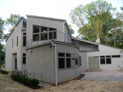 A white house with a balcony and a lot of windows