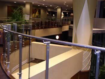 A hotel lobby with a glass railing and stairs.
