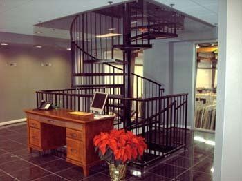 A spiral staircase with a desk in front of it