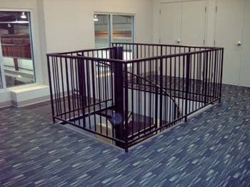 A room with a spiral staircase and a metal railing.