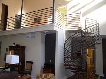 A living room with a spiral staircase leading to the second floor