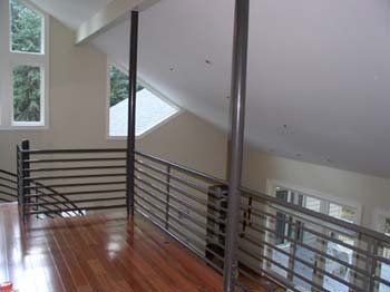 There is a balcony with a railing in the middle of the room.