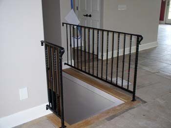 A staircase with a wrought iron railing leading to a basement.