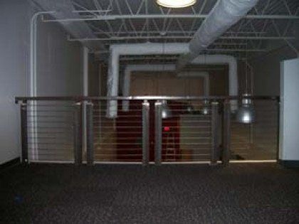 There is a balcony with a metal railing in the middle of the room.