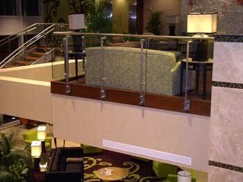 A hotel lobby with a glass railing and a green couch