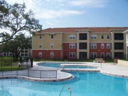 A large apartment building with a large swimming pool in front of it.