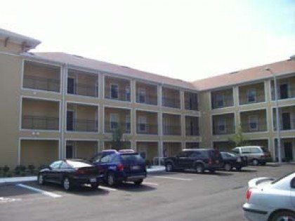 A large apartment building with cars parked in front of it.