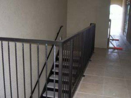 A staircase with a metal railing leading up to the second floor of a building.