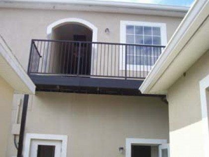 A building with a balcony and stairs leading up to it.