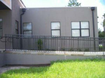 A building with a fence around it and a ramp leading to it.